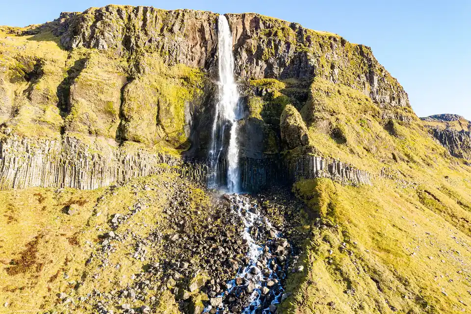 La cascade de Bjarnarfoss tombant le long d’une paroi de basalte, sur la péninsule de Snæfellsnes