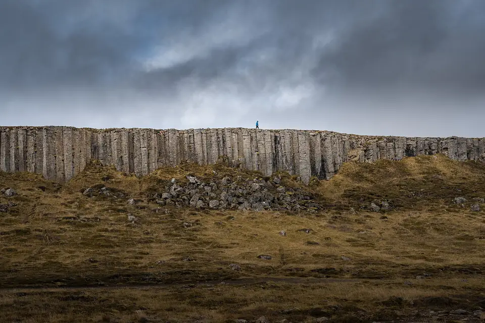 Lange Basaltwand von Gerðuberg unter dunklen Wolken