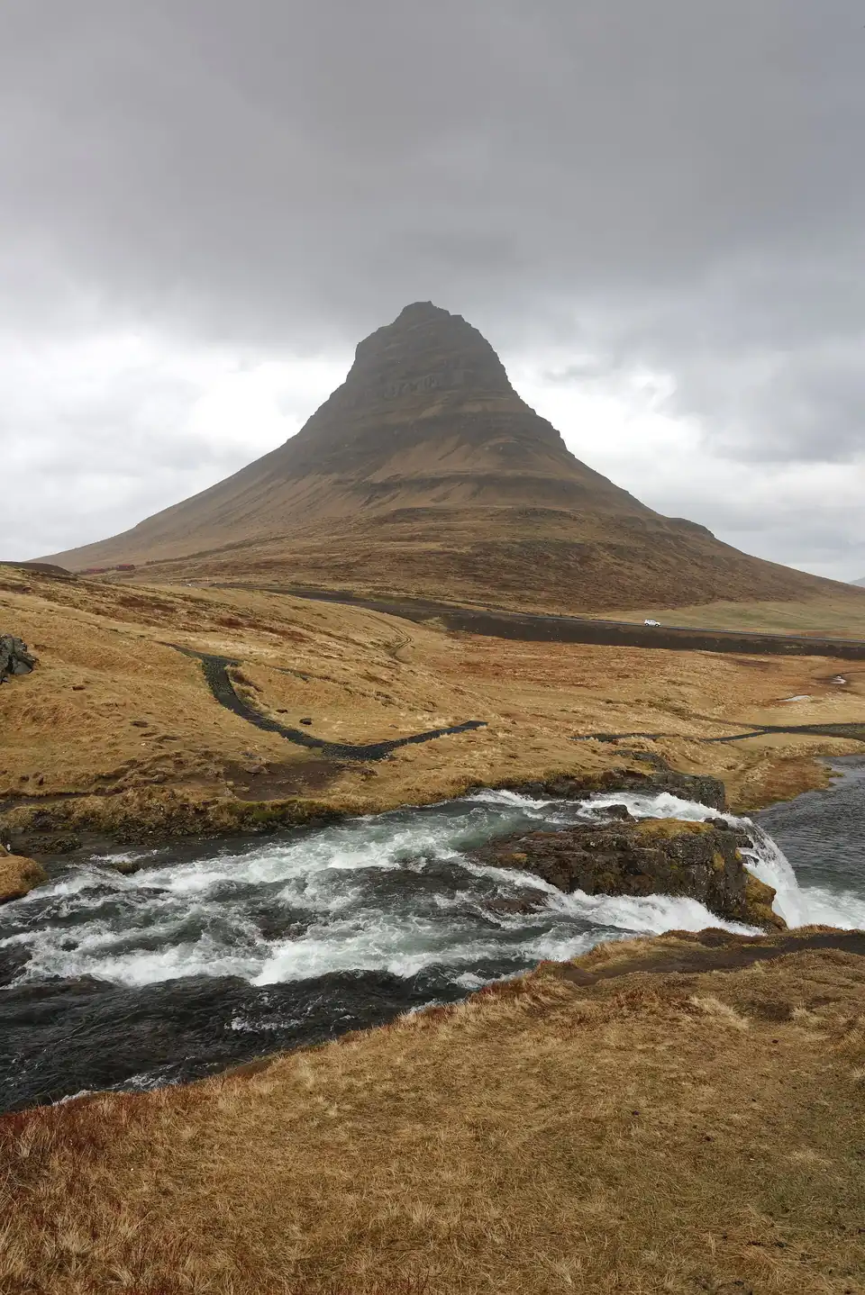 Le Kirkjufell derrière les cascades étagées du Kirkjufellsfoss, format portrait, au printemps