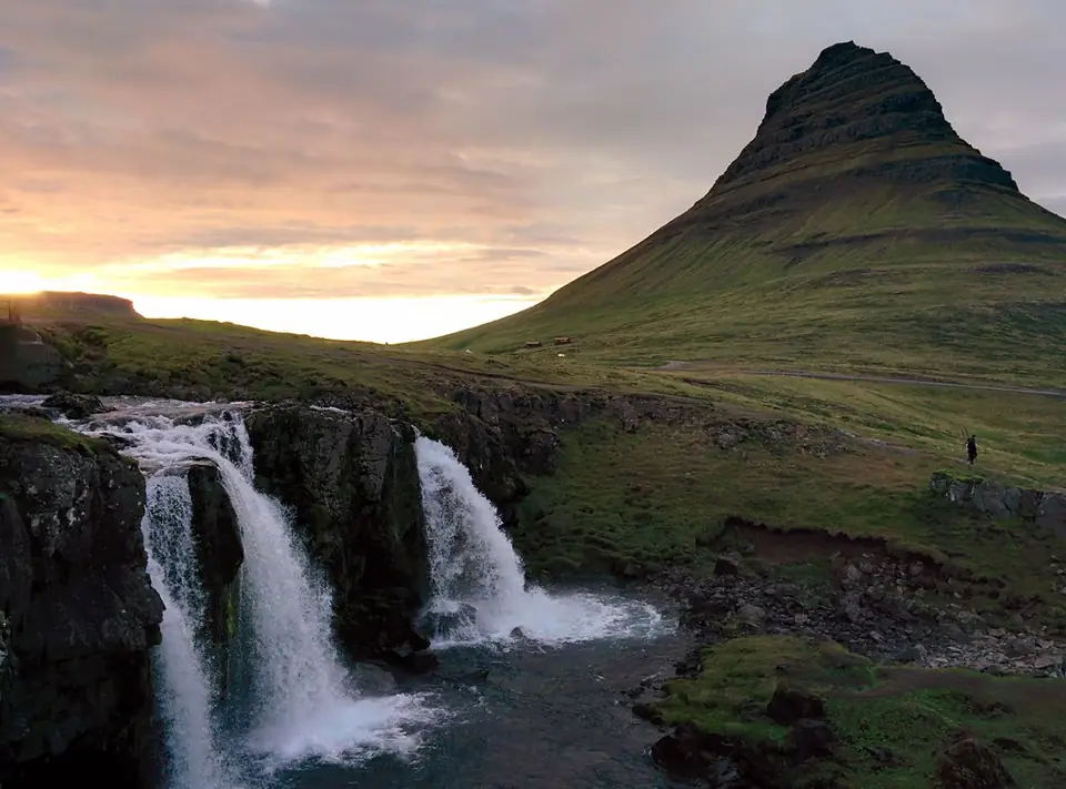 Kirkjufell und Kirkjufellsfoss im Abendlicht mit Wolken