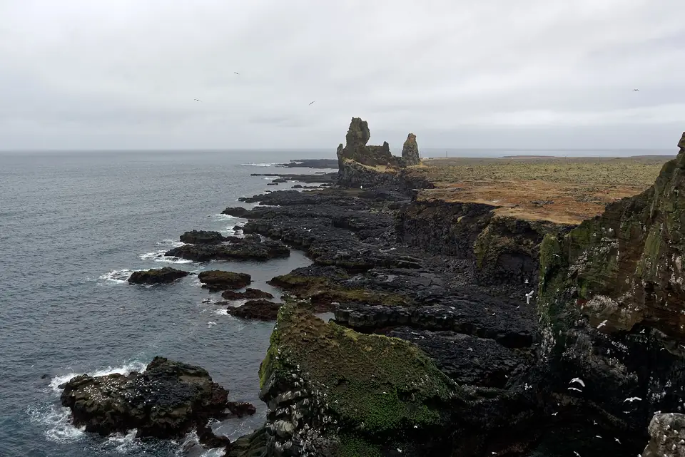 Die Felsnadeln von Lóndrangar an der Küste mit Lava und Meer