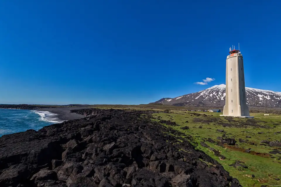 Der Leuchtturm von Malarrif mit dem verschneiten Snæfellsjökull im Hintergrund